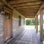 Covered porch with slatted rafters, cedar shingles and an onion lantern beside the door