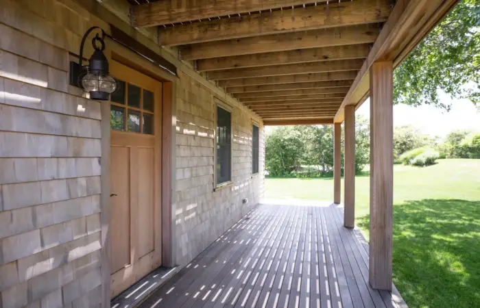 Covered porch with slatted rafters, cedar shingles and an onion lantern beside the door