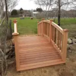 A custom-built wooden bridge with cedar railings in a Nantucket backyard. Build by R. Bradley builders of Nantucket.