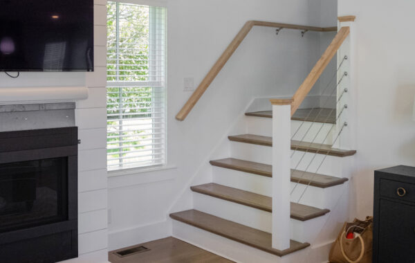 A guest home on Nantucket showcasing custom carpentry. The space includes finely crafted wooden elements, built-in shelving, elegant wood trim, and unique architectural details, highlighting the skillful craftsmanship and attention to detail in the home's design.