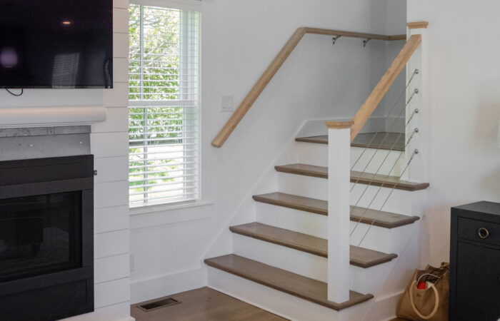 A guest home on Nantucket showcasing custom carpentry. The space includes finely crafted wooden elements, built-in shelving, elegant wood trim, and unique architectural details, highlighting the skillful craftsmanship and attention to detail in the home's design.