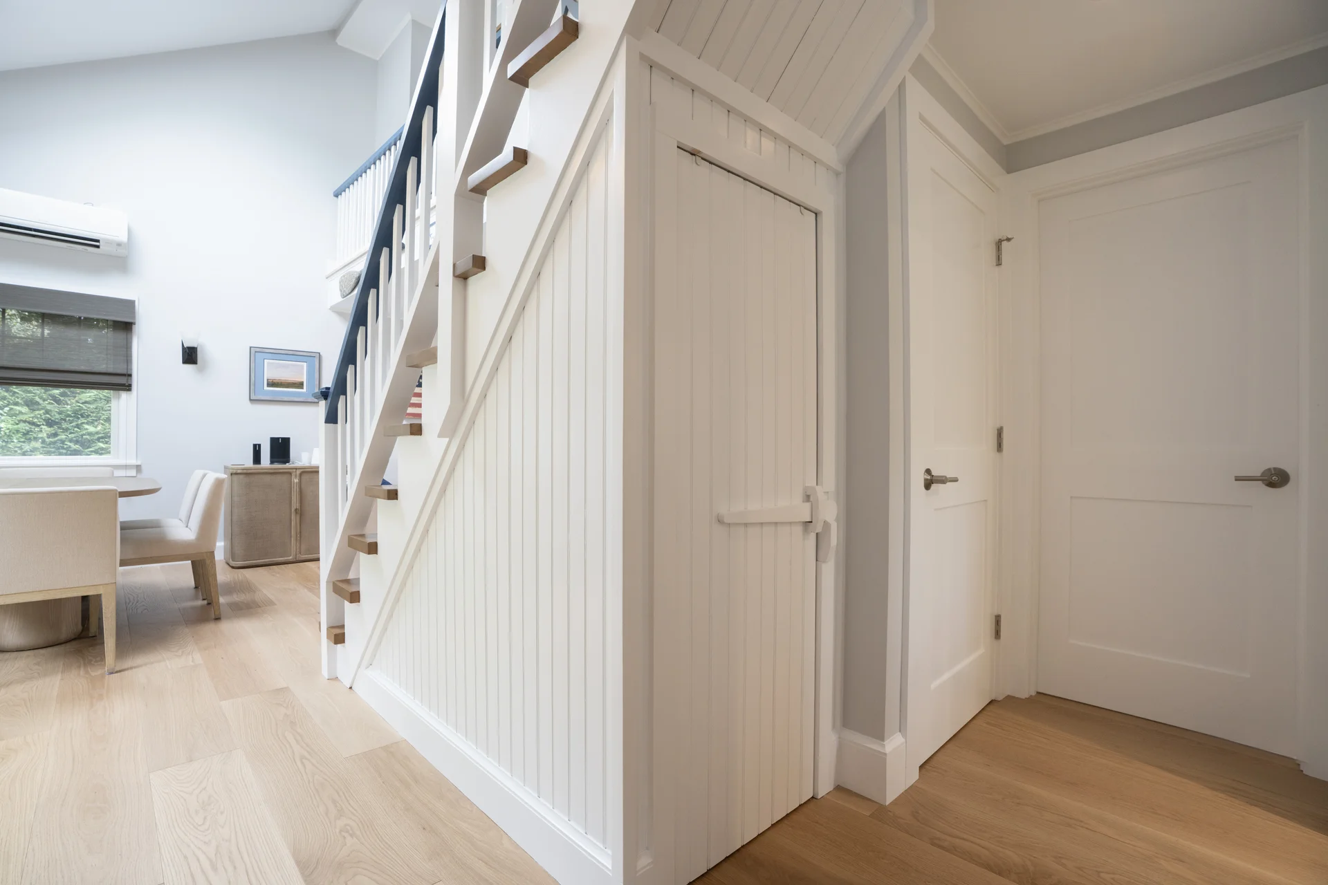 Custom entryway with elegant staircase in renovated Nantucket home