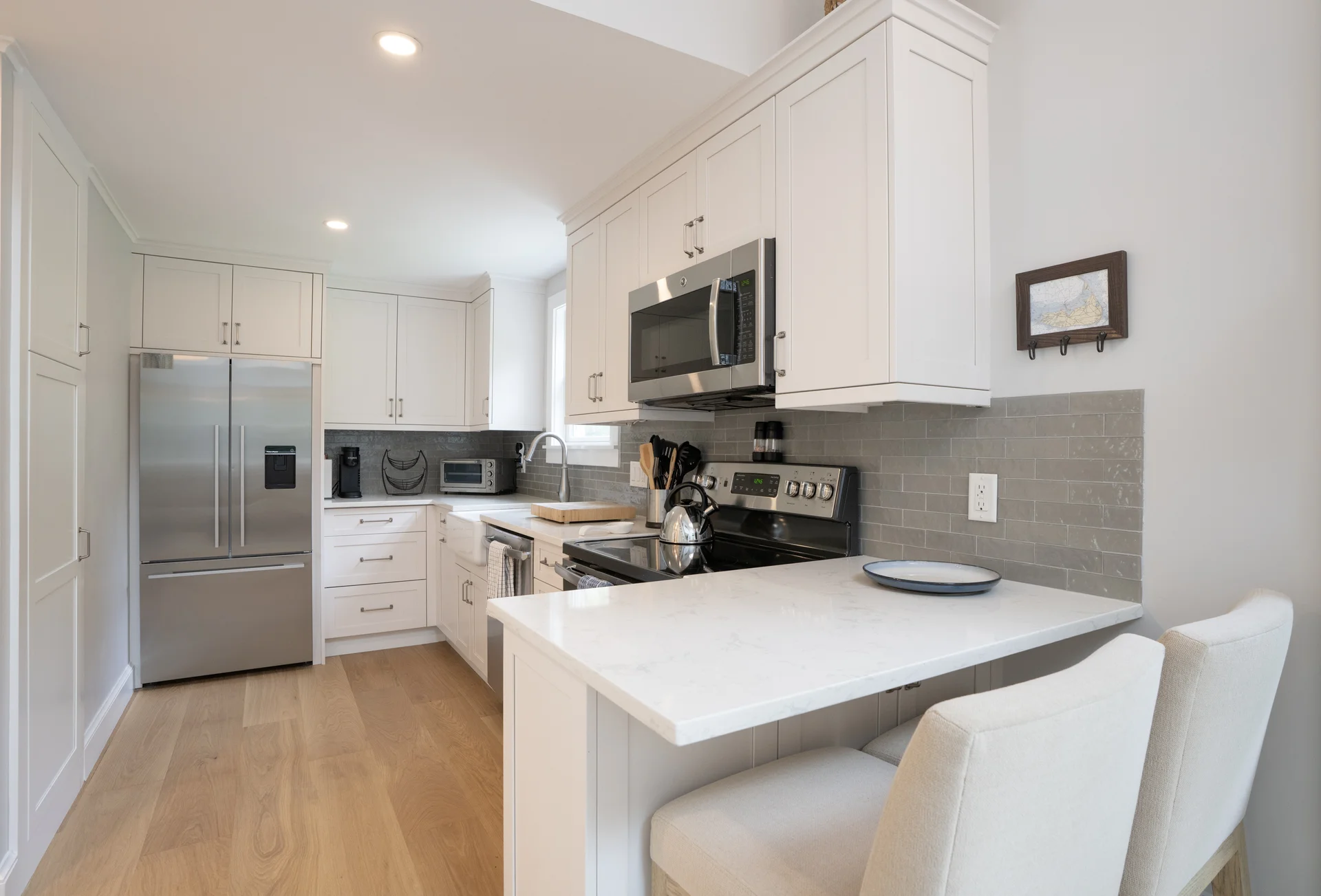 Modern kitchen with white cabinets and island in Nantucket renovation