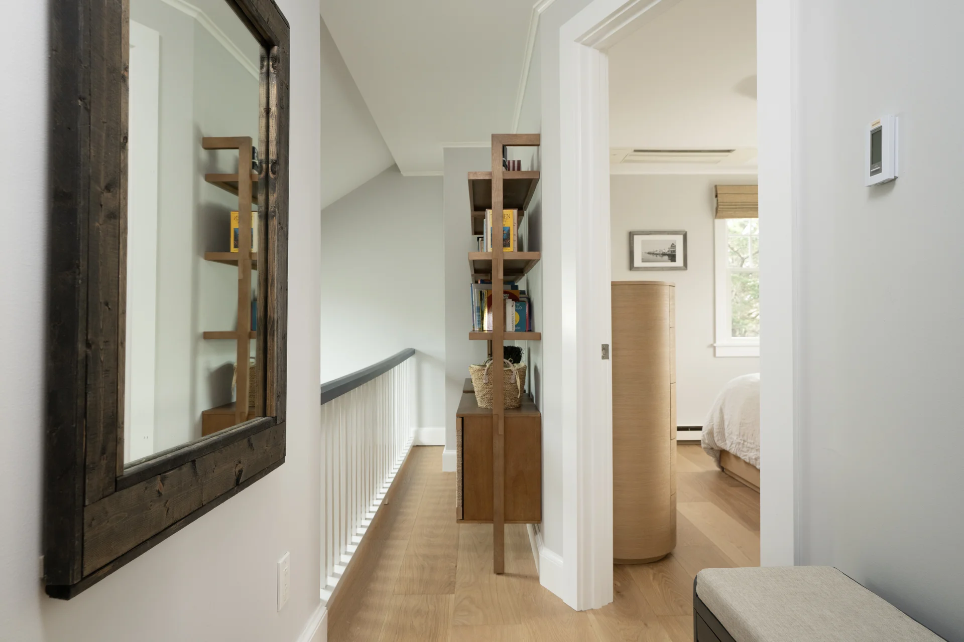 Upstairs hallway with rustic mirror in renovated Nantucket home