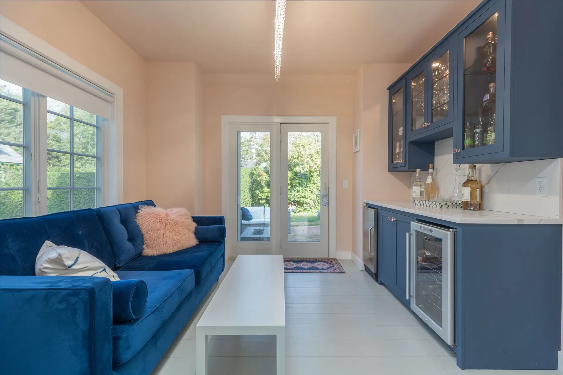 Custom bar and lounge area with navy velvet sofas and wine fridge