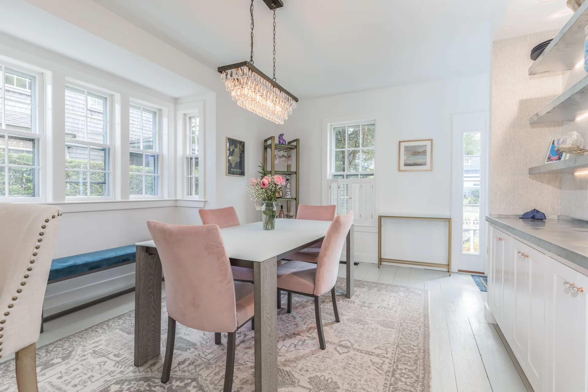 Dining room with crystal chandelier and pink upholstered chairs