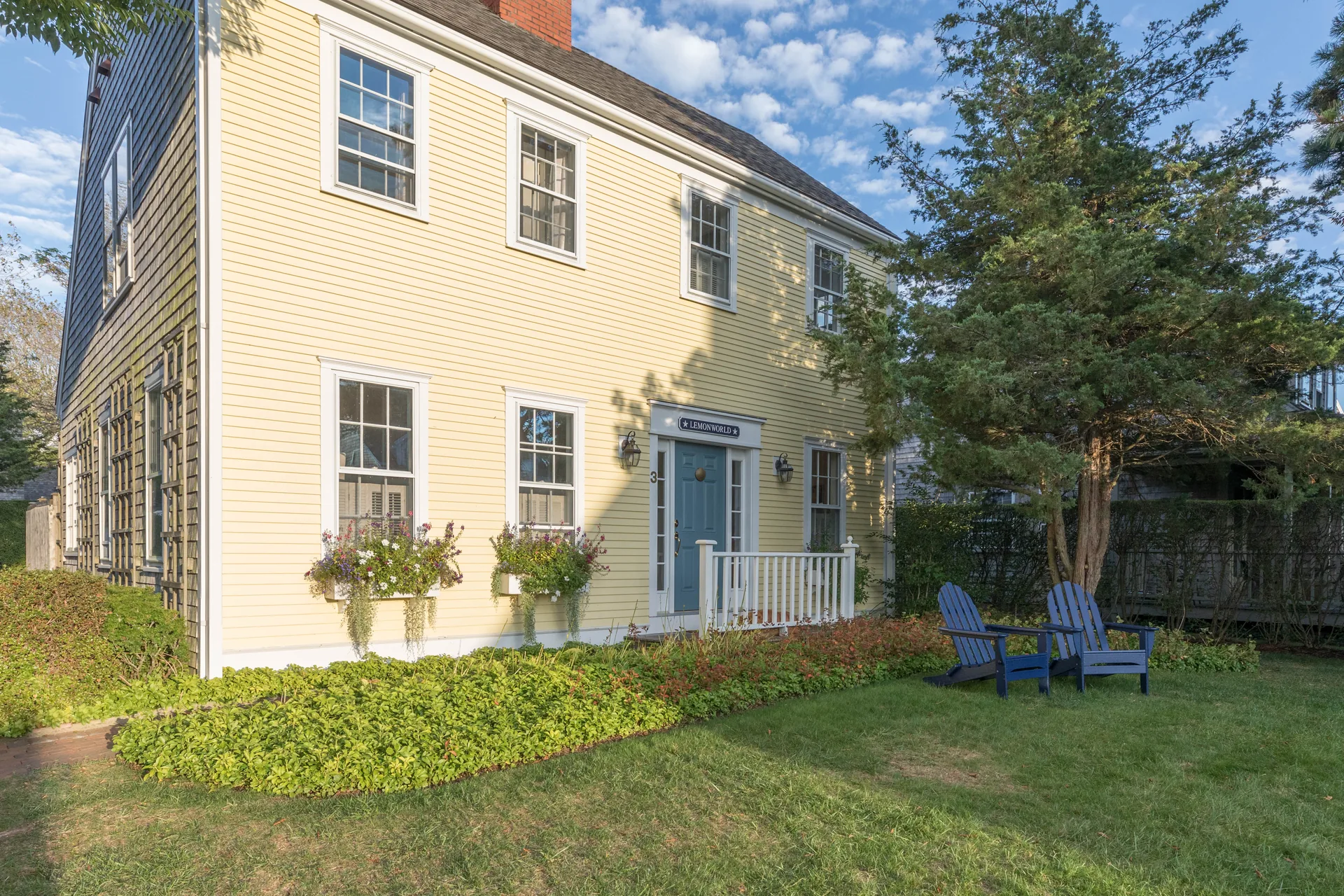 Front porch with Lemonworld sign and blue Adirondack chairs