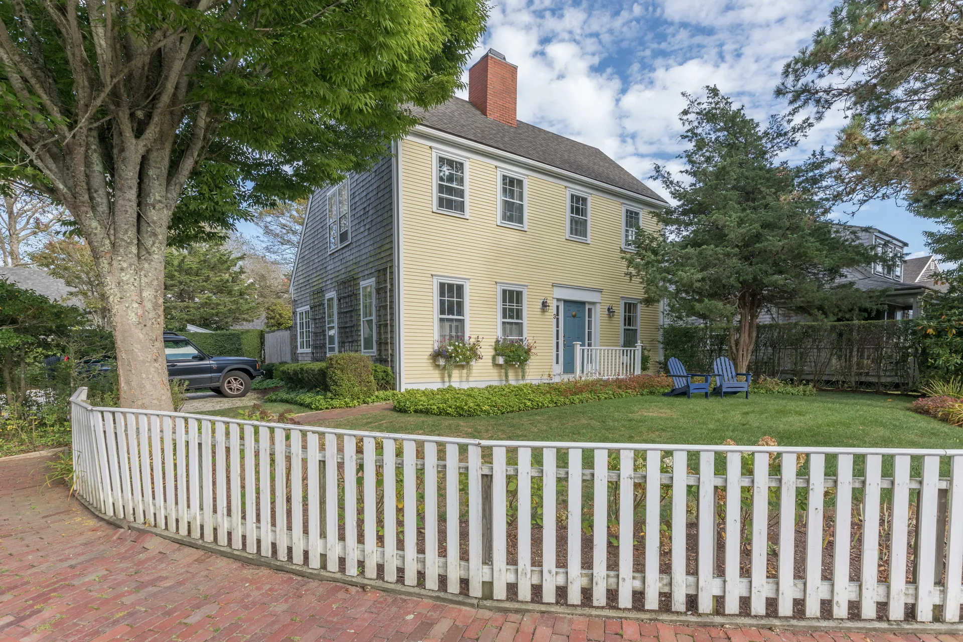 Netowa Lane home exterior with white picket fence and colonial architecture