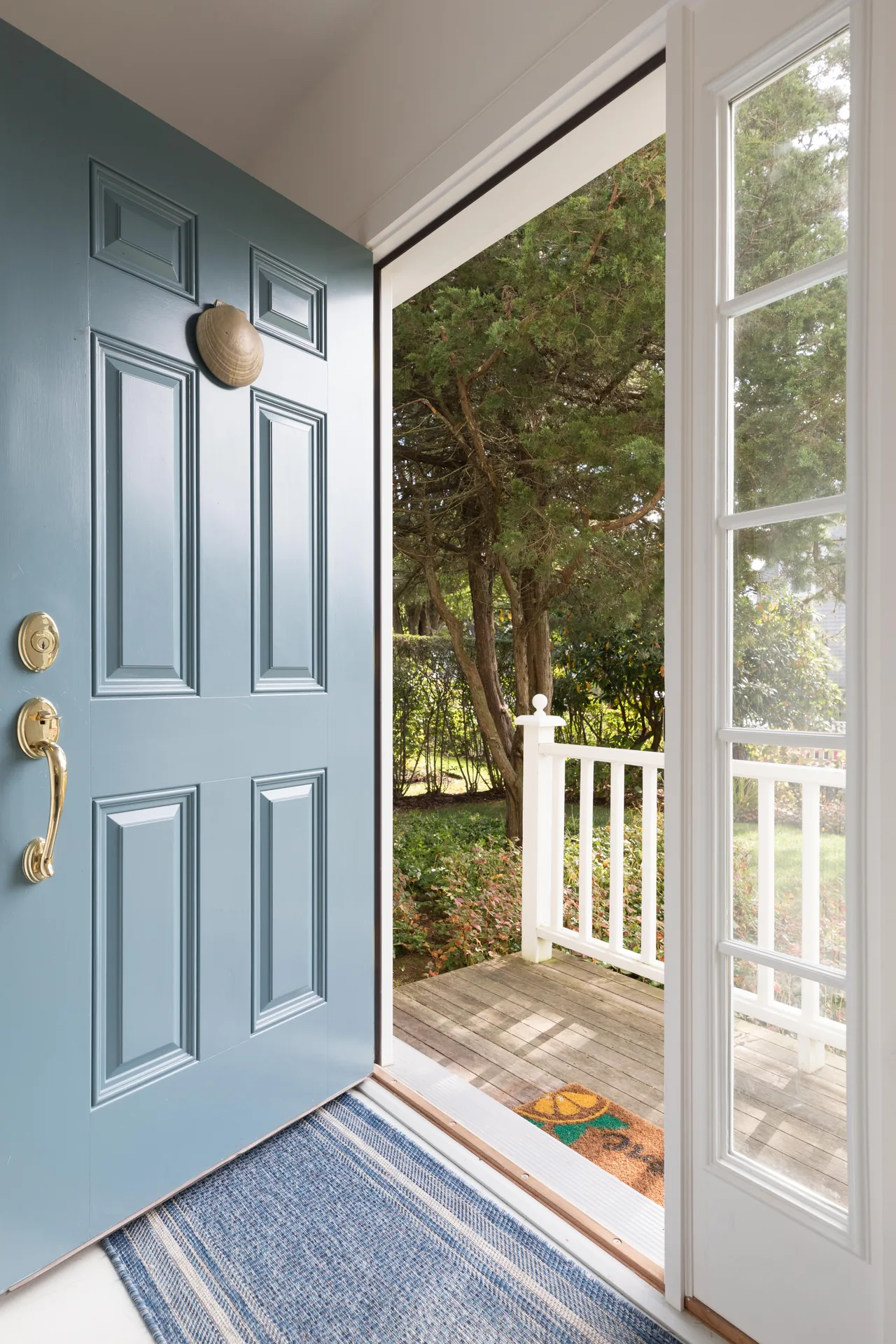 Front entry with blue door and decorative shell knocker