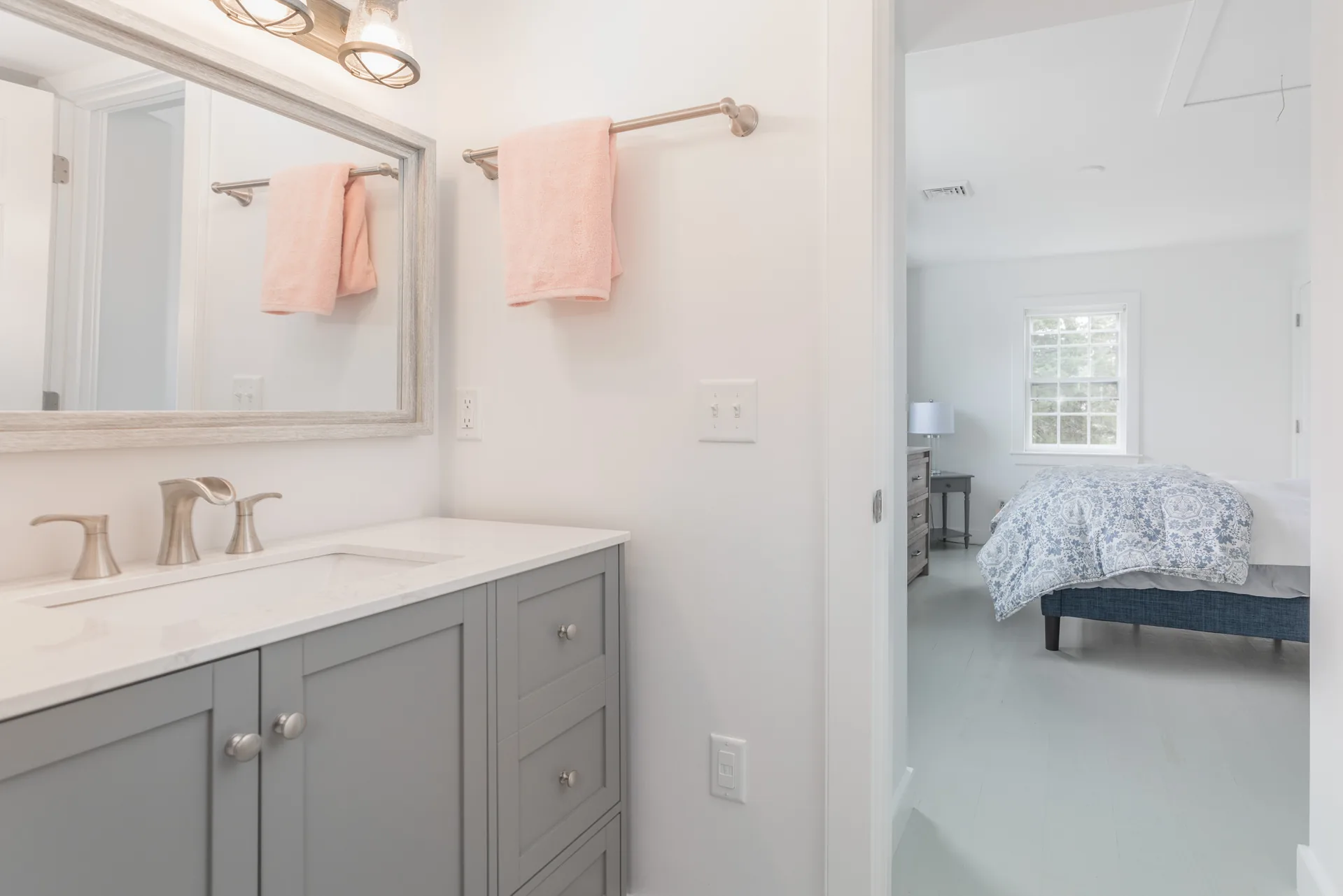 Guest ensuite bathroom with gray vanity and driftwood mirror