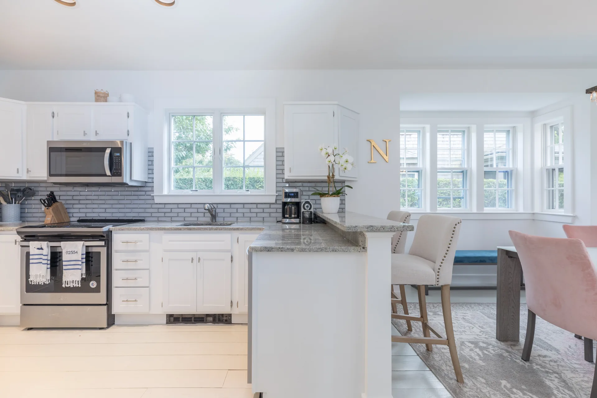 Kitchen peninsula with bar stools opening to dining area