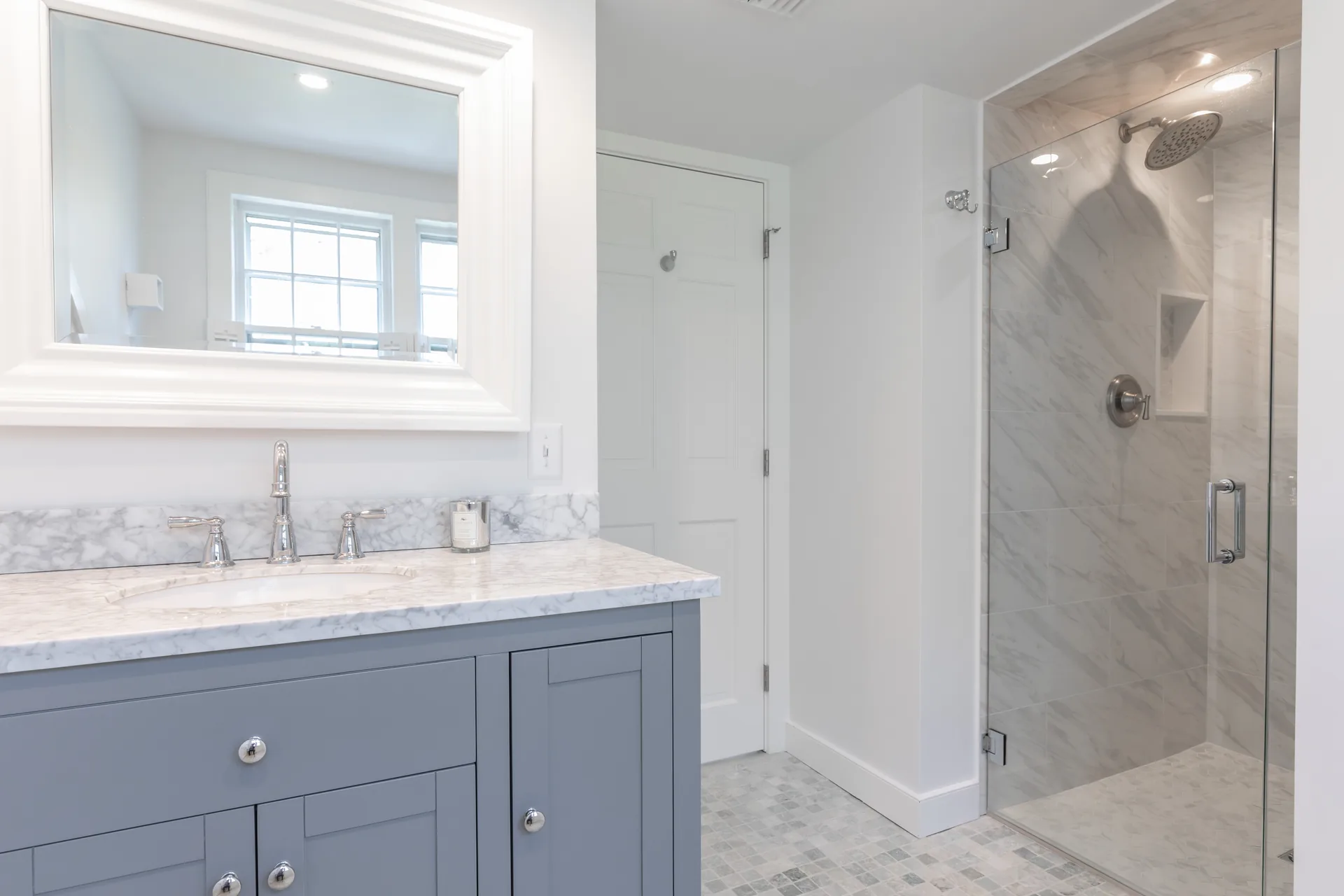 Master bathroom with blue vanity and glass shower enclosure