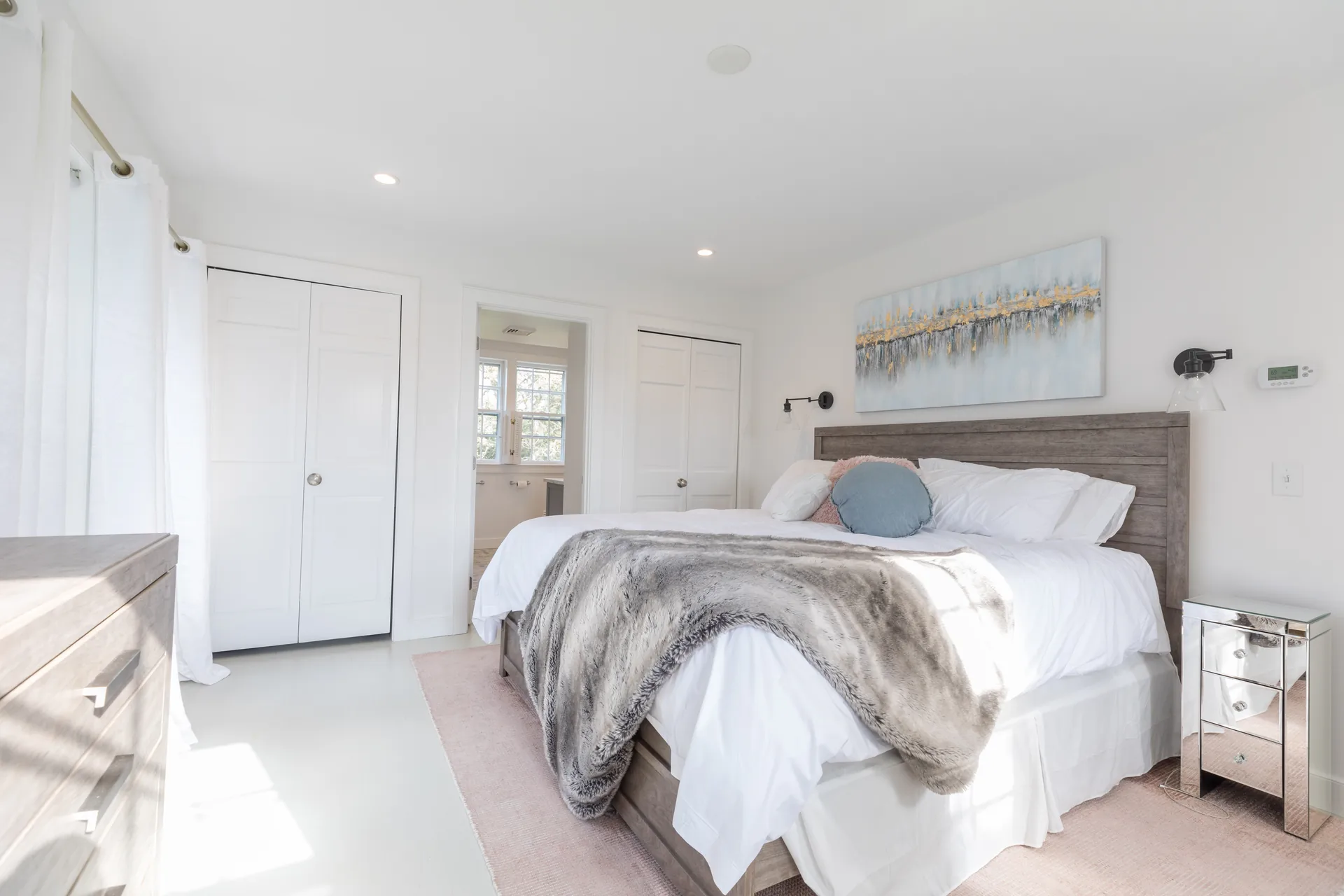 Master bedroom with wood headboard and abstract art
