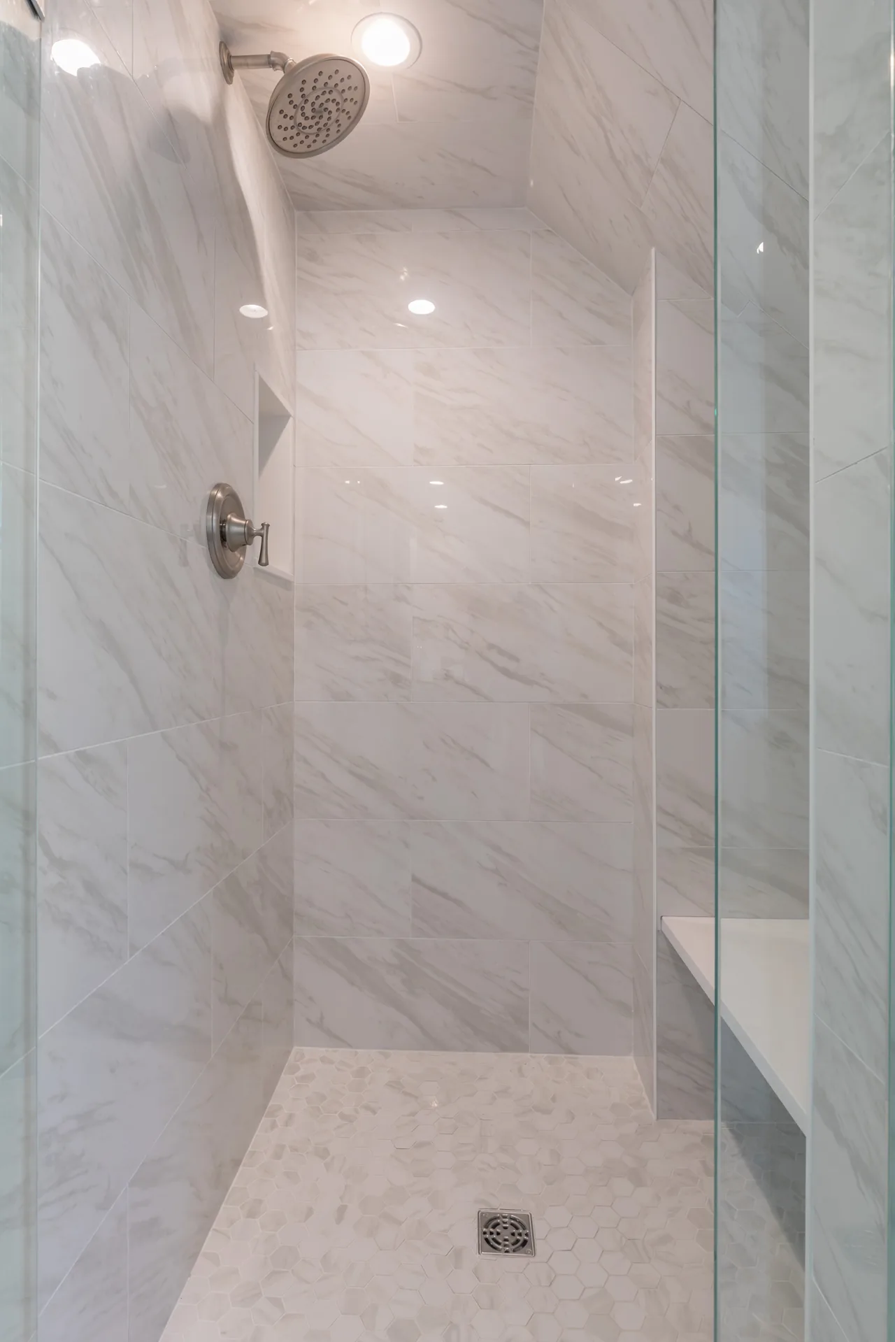 Walk-in shower with marble tile and rain showerhead
